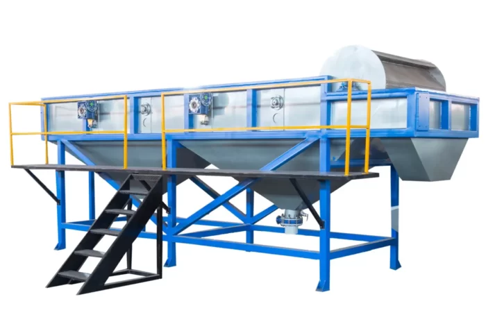a plastic floating separation tank, an essential component in the recycling process for different types of plastics. This system utilizes the difference in density between various plastic materials to separate them in a water-based solution. The setup includes a large tank with a blue base and transparent sides, allowing for monitoring of the separation process. It is mounted on a sturdy blue and yellow metal framework with stairs for access. These tanks are crucial for effectively sorting plastics, which is a critical step in ensuring the purity and quality of recycled materials.